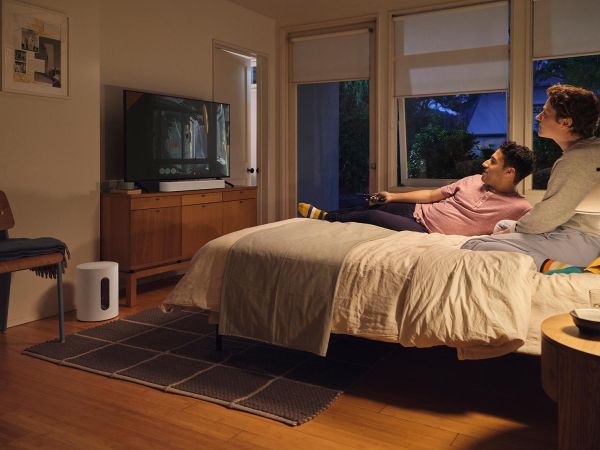 Serene bedroom with a person relaxing and a Sonos speaker for ambient sound