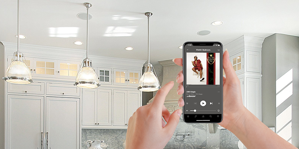 hands holding phone controlling in ceiling speakers