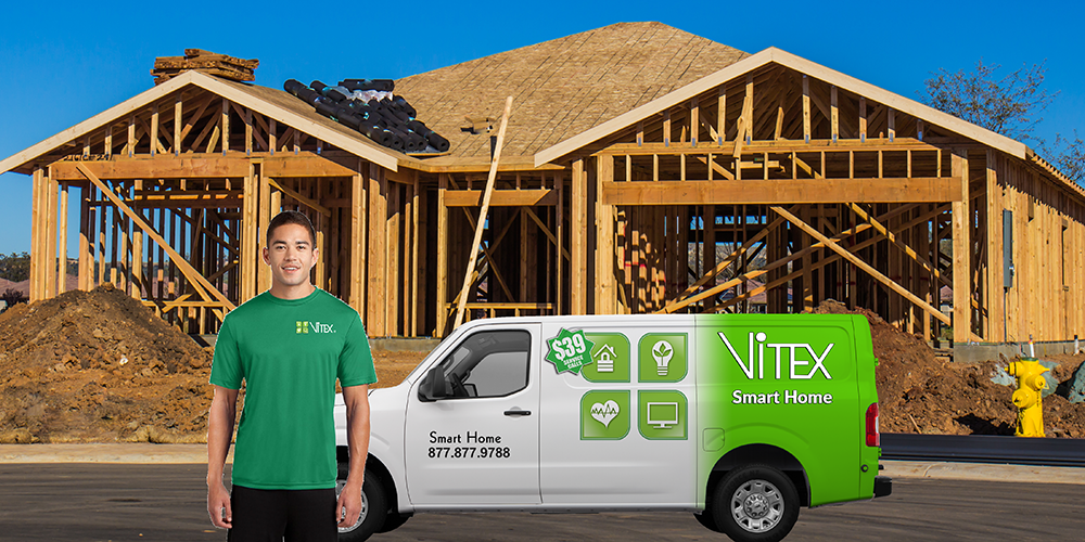 home automation installer standing in front of his commercial vehicle in front of a home that is being built